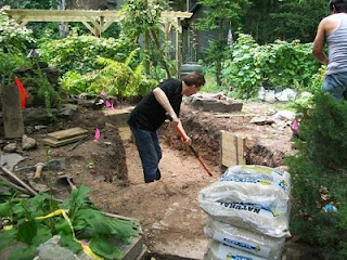 Garden members dig an enclosure for a pond. 