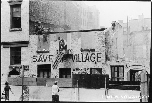 At 10th St and Greenwich Ave, demolishers dismantle a former sculptor's studio, the facade of which is painted with the slogans 'Save the Village' and 'Wake Up Mr. Mayor!' New York, New York, May 16, 1960. (Photo by Fred W. McDarrah/Getty Images)