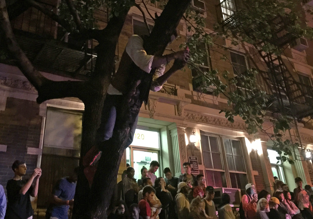 by: Daniel Maurer of Bedford & Bowery. Crowd in front of East 11th Street buildings that might be demolished to make way for a 300 room hotel anticipating Kanye West performing. 