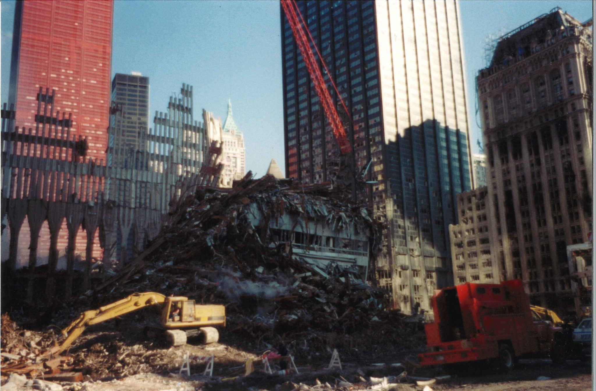 A Digger and Crane Working Through Debris in front of One Liberty Plaza