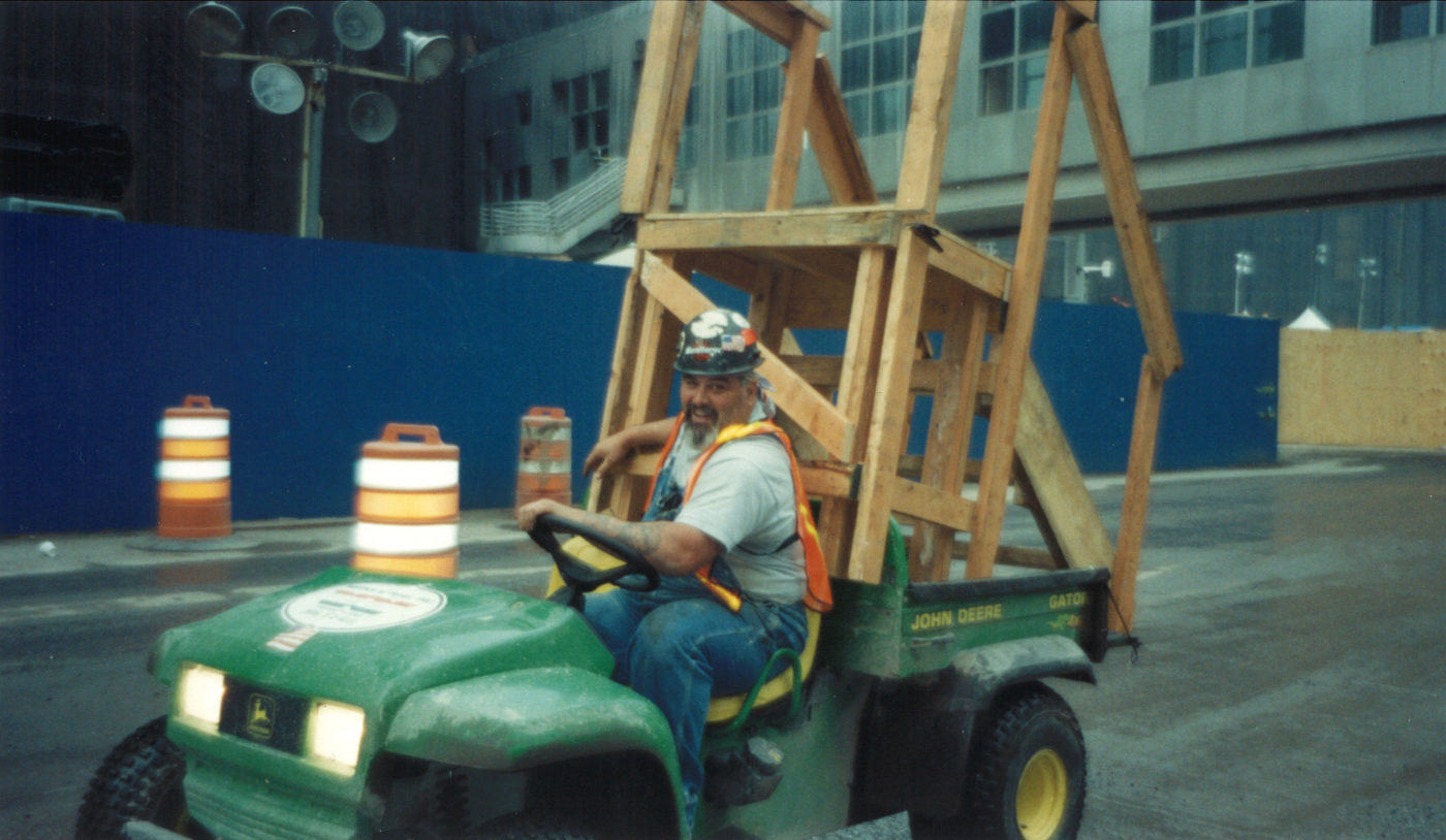 Unknown Worker Driving a Wooden Stair on the Back of a Cart Through Ground Zero