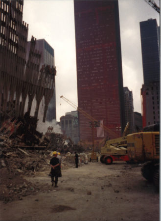 Work at Ground Zero in front of falling exoskeleton and a sheathed One Liberty Plaza