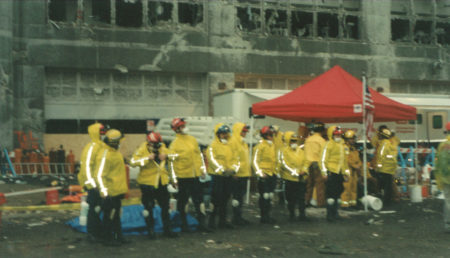 Workers Stand in HighVis Jackets near Tent