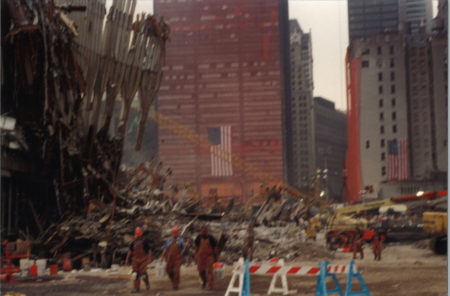 Workers Walking Near Falling Exoskeleton with Sheathed One Liberty Plaza in the Back