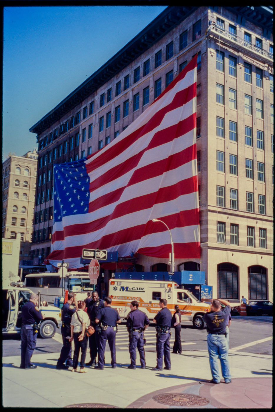 Ambulance Passes as Police and Passerby Stand Near American Flag at Hubert and Greenwich Streets.jpg