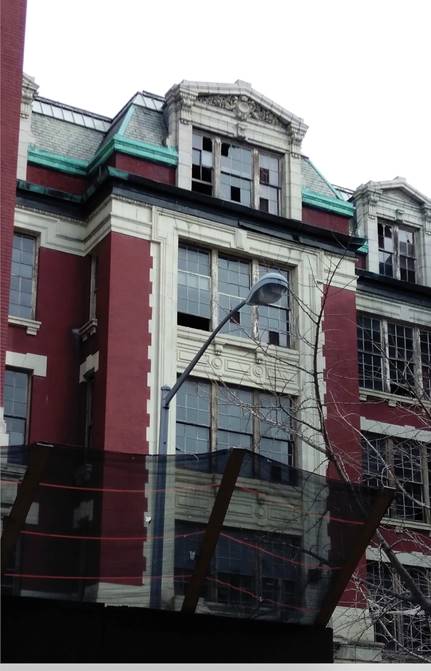 Decrepit public school building with netting above ground floor