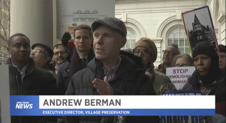 Andrew Berman speaking at press conference at City Hall, in front of crowd of people, with his name and the Spectrum News logo logo below jim on screen